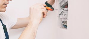 Closeup of an electrician working on an electrical panel in a client's home. 