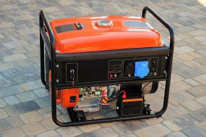 Portable gas generator sitting on a patio. 