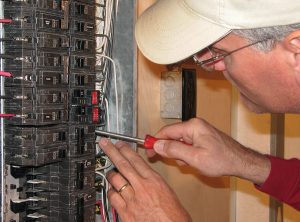 Electrician making connections in breaker box