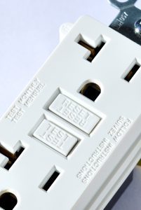 Partial image of two-plug electrical outlet with ground fault gf protection and reset buttons.