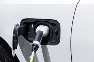 Closeup of a white electric vehicle being charged. 