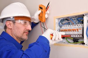 Electrician working on an electrical panel. 