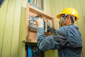 Electrician working on an electrical panel in a home. 