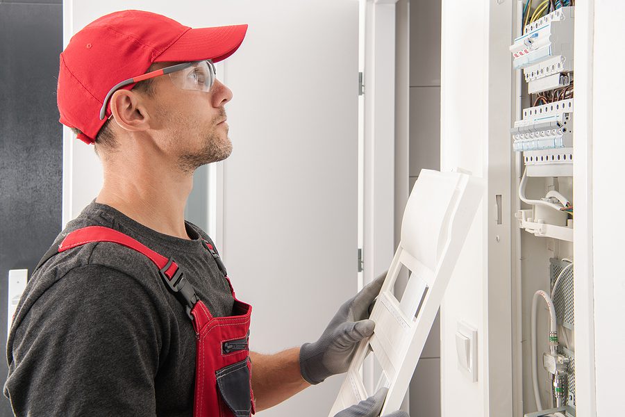 Male electrician working on an electrical panel upgrade in a home. 
