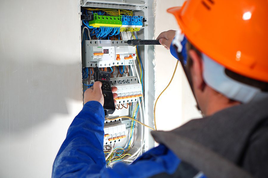 Closeup of an electrician testing an electrical switchboard.