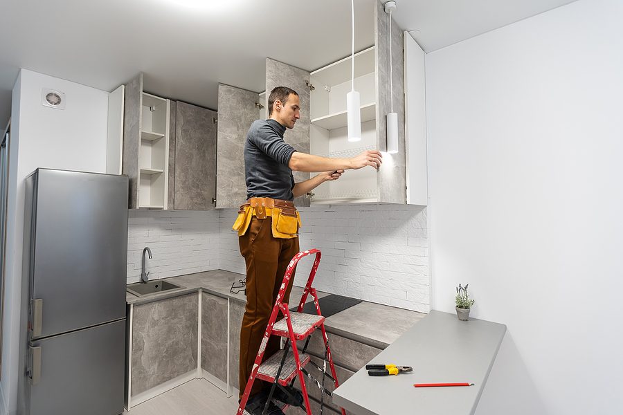 Electrician working on lighting upgrade during a home renovation.