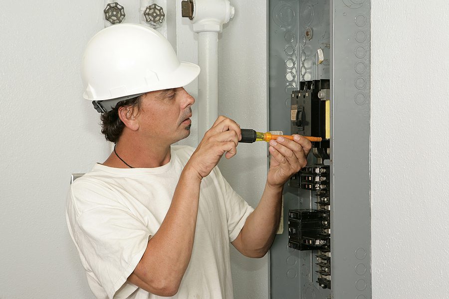 Electrician installing a breaker on an electrical panel